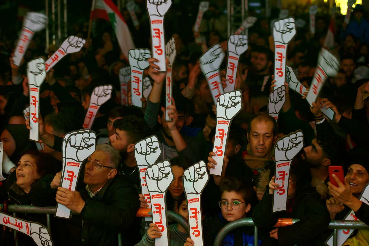 epa08097012 Lebanese anti-government protesters and citizens hold cut outs during New Year's Eve celebrations at Martyrs' Square in Beirut, Lebanon, 31 December 2020. EPA/WAEL HAMZEH