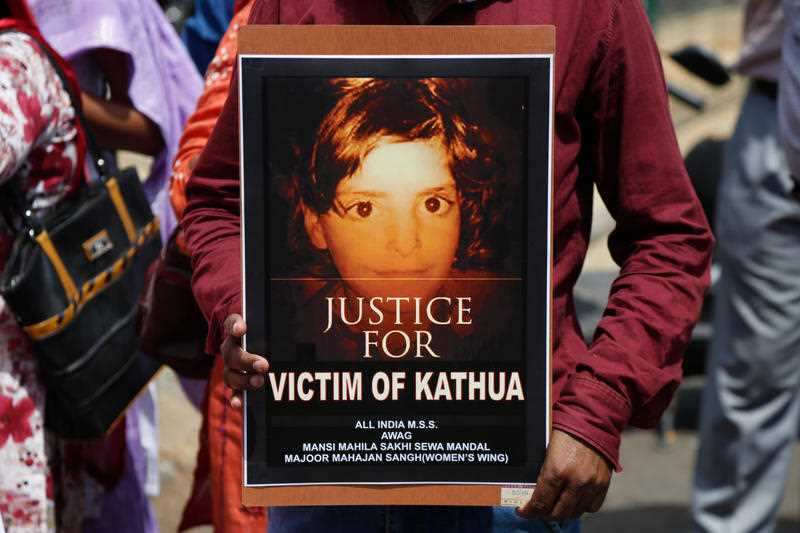 An Indian woman holds a poster with a portrait of Asifa, an 8 year-old girl who was grazing her family's ponies in the forests of the Himalayan foothills when she was kidnapped and her mutilated body found in the woods a week later, in Srinagar, India.