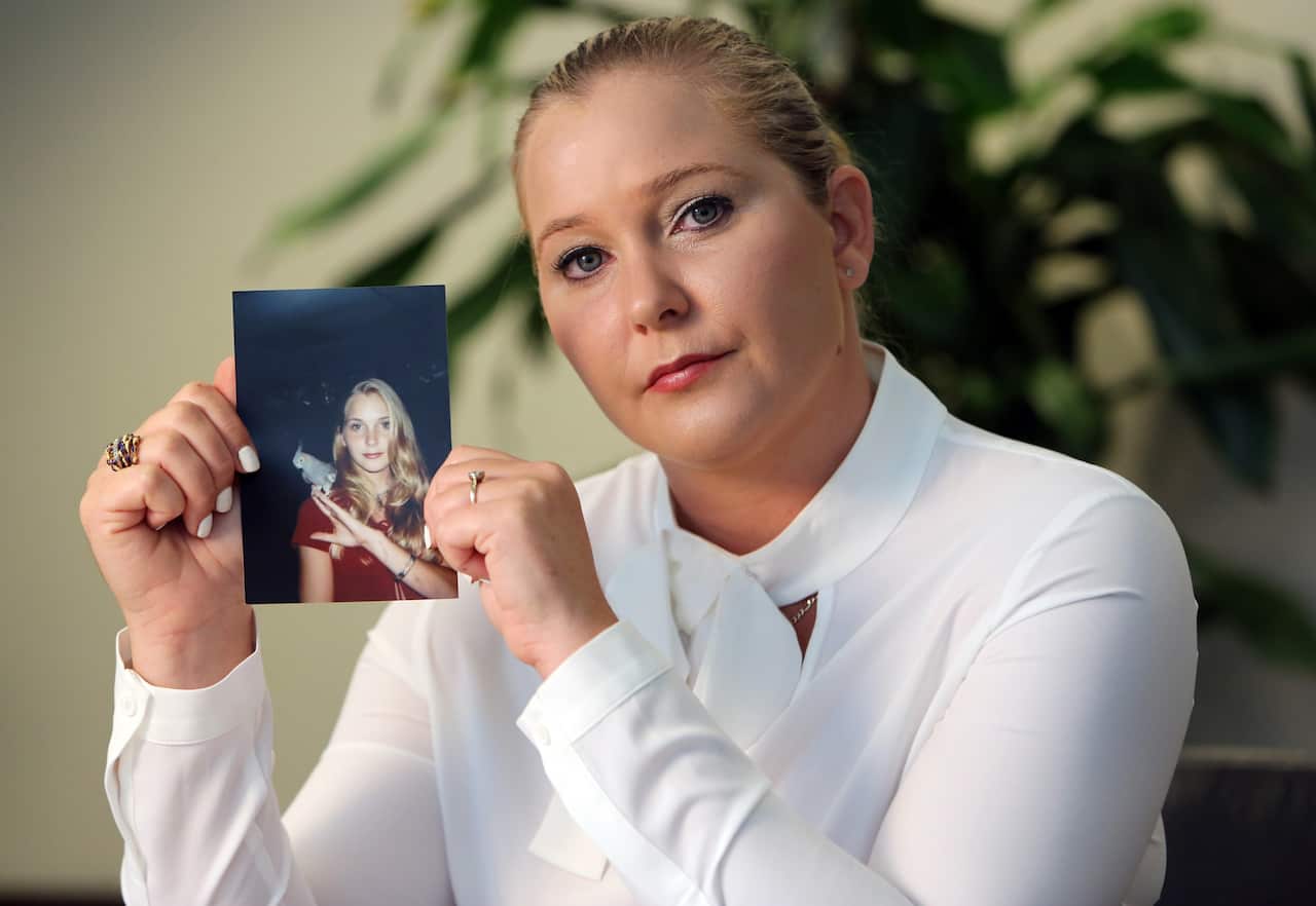 Virginia Giuffre holds a photo of herself at age 16, when she says Jeffrey Epstein began abusing her sexually.