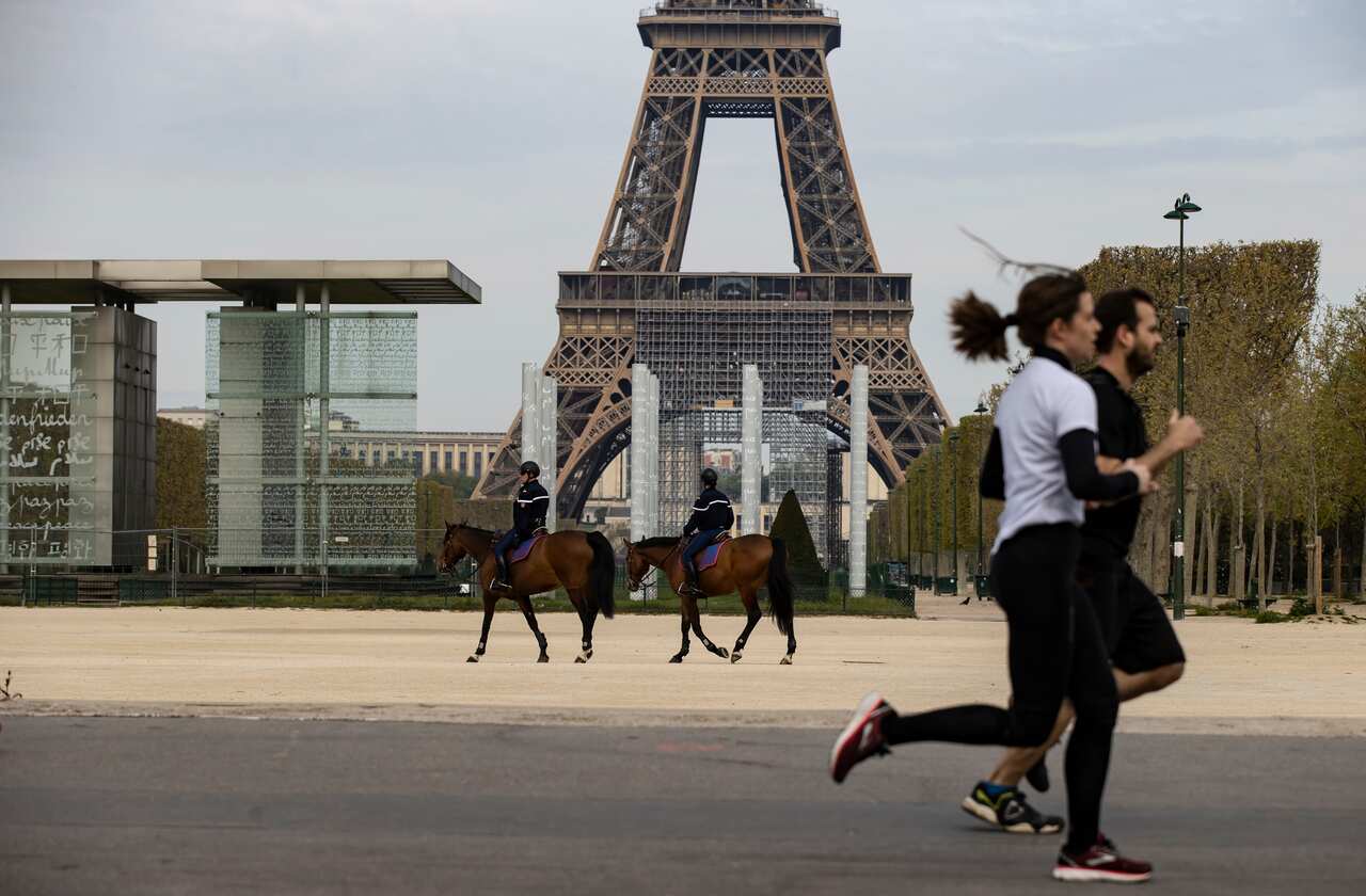 Gendarmery patrol as joggers run past the Eiffel Tower and the Champs de Mars, in Paris, 7 April 2020.