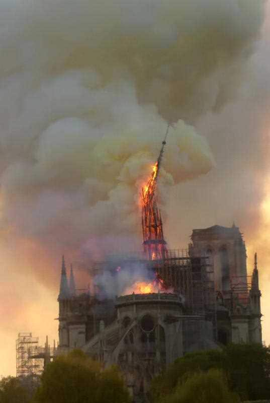 Flames and smoke rise as the spire of Notre Dame cathedral collapses.