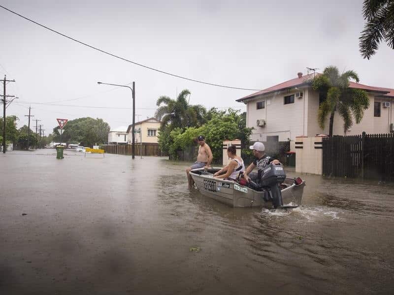 Residents navigate floodwaters in Rosslea near Townsville.