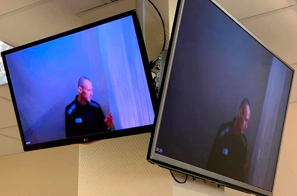 April 29, 2021, Russian opposition leader Alexei Navalny is seen on TV screens gesturing during a hearing on his charges for defamation in Moscow, Russia.