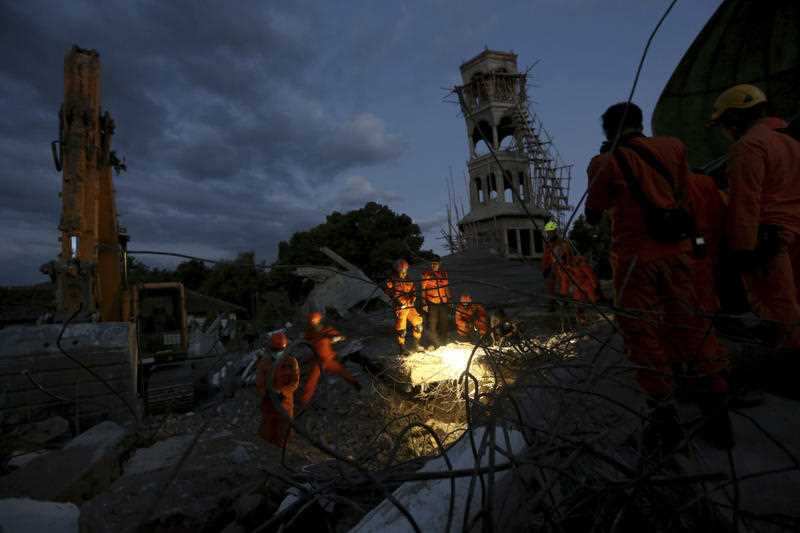 Rescue teams search for victims in the rubble caused by an earthquake at a Mosque in North Lombok, Indonesia, Monday, Aug. 6, 2018.
