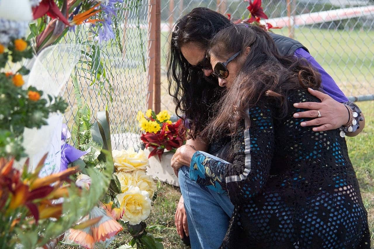 Bouquets of flowers are placed on the waterfront near the White Island Tours base.