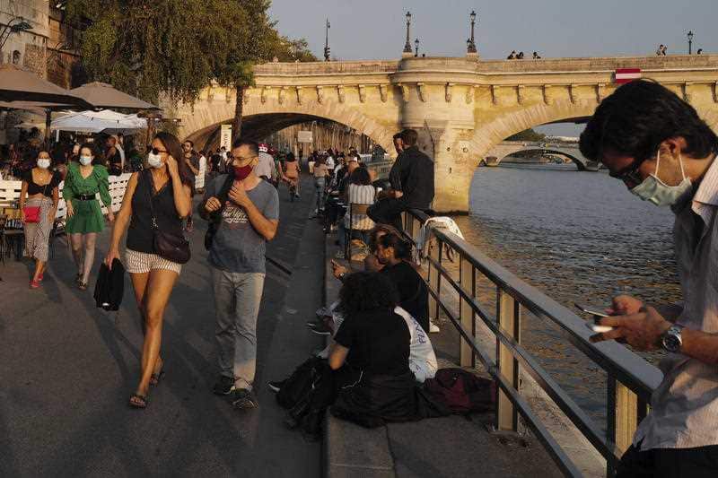 People seen wearing protective face mask walk along the Seine river bank in Paris on 11 September.
