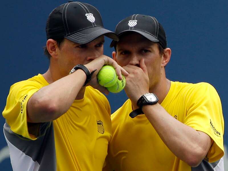 Bob Byran, left, and Mike Bryan talk between points against Daniel Nestor, of Canada, and Vasek Pospisil, of Canada, during a doubles match at the 2013 U.S. Open tennis tournament, Sunday, Sept. 1, 2013, in New York. (AP Photo/David Goldman)