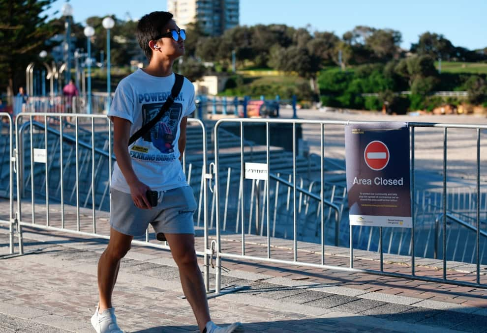 A beachgoers walks past a closed entry point to Coogee Beach in Sydney, Friday, April 24, 2020