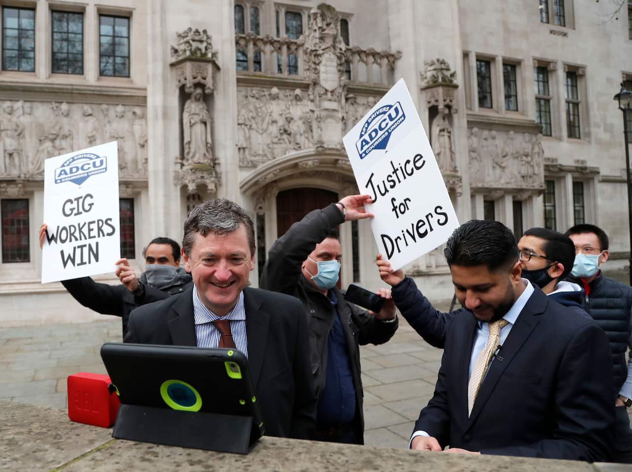 Uber drivers of the (ADCU), App Drivers & Couriers Union, celebrate as they listen to the court decision