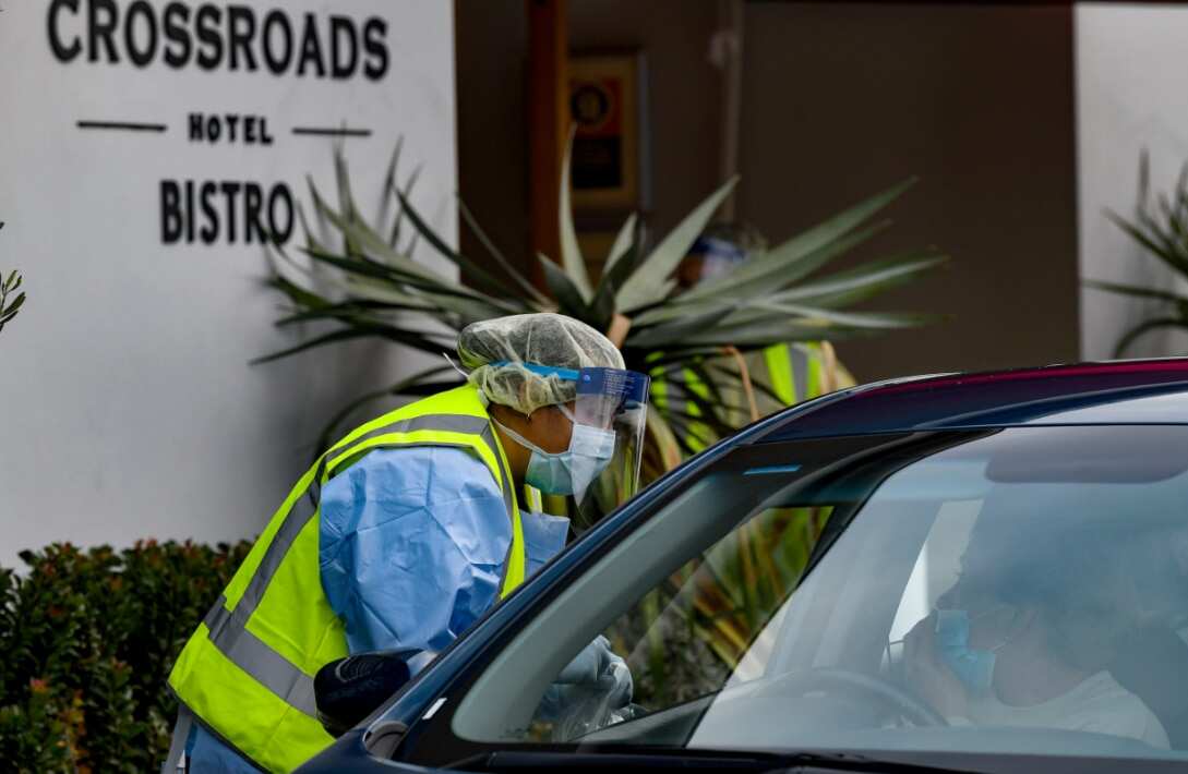 Workers administering COVID-19 tests to people in their cars at the Crossroads Hotel testing centre in Sydney, Saturday, July 11, 2020
