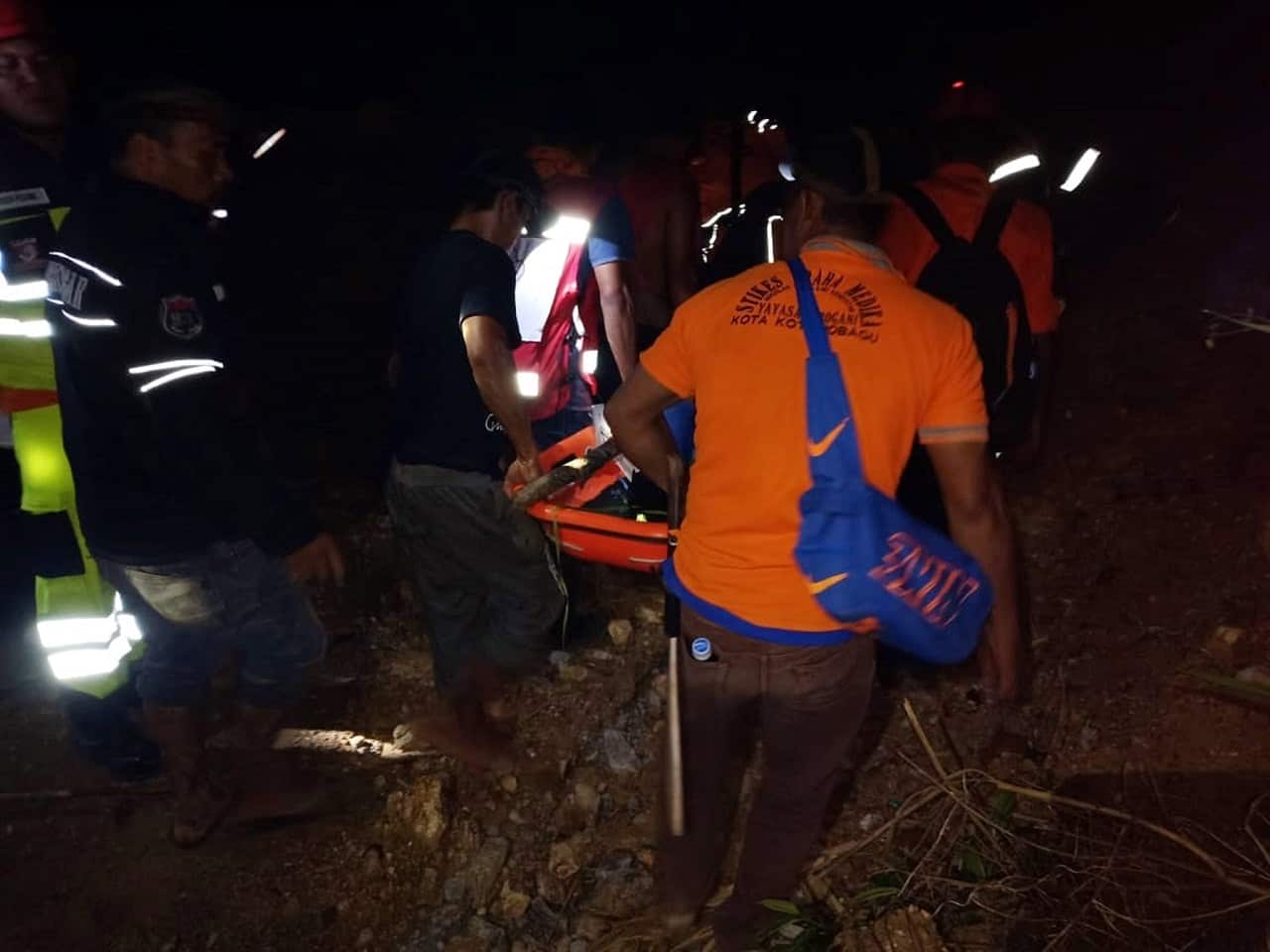 Rescuers carry a survivor.