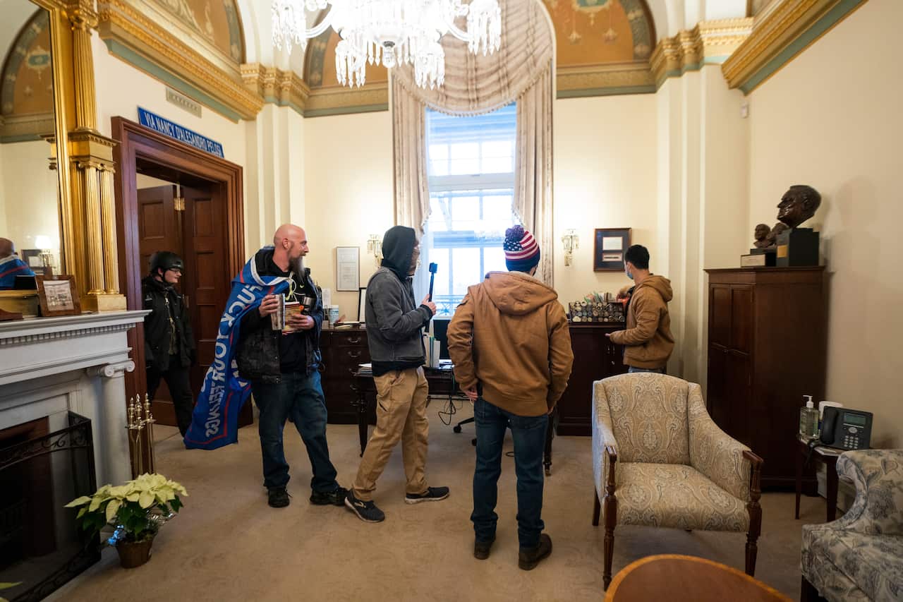 Supporters of US President Donald Trump stand inside the office of House Speaker Nancy Pelosi on Wednesday.