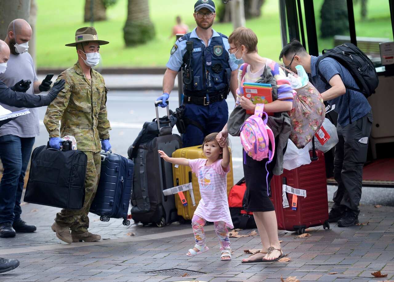 Returning overseas travellers are ushered into the InterContinental Hotel for the beginning of their 14-day imposed quarantine in Sydney.