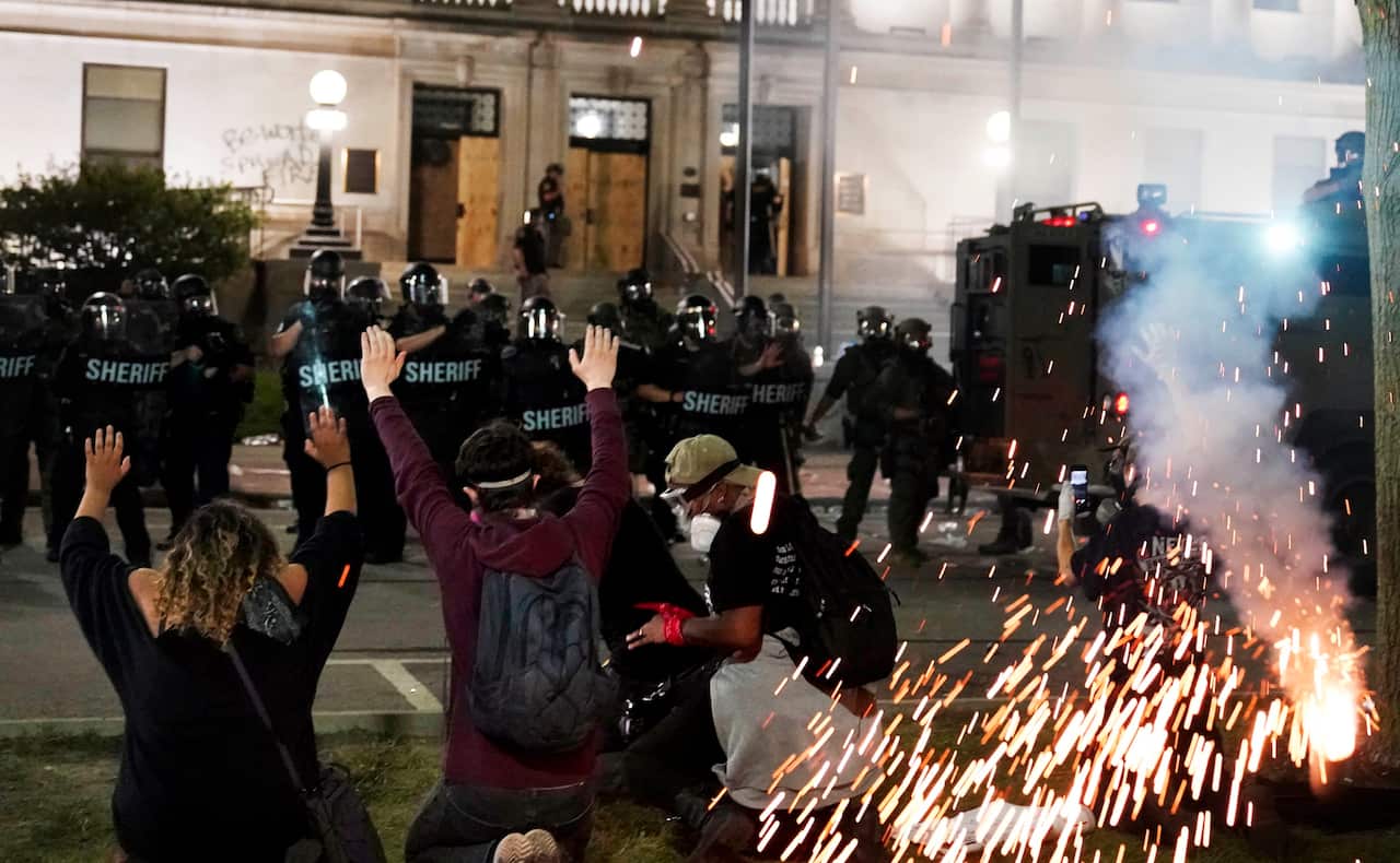 Police attempt to push back protesters outside the Kenosha County Courthouse (AAP)