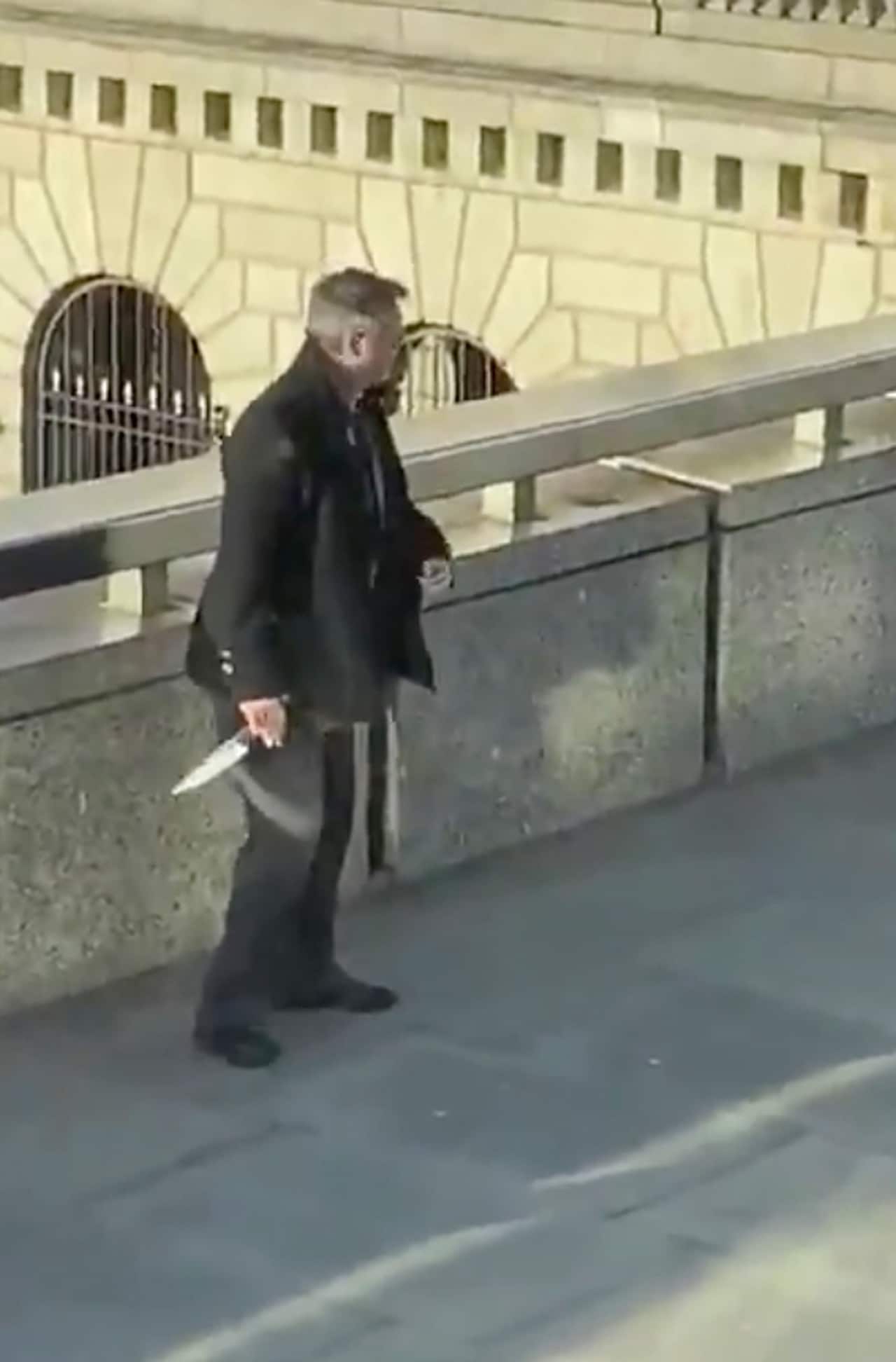 A bystander holds a knife, after police shot the offender.