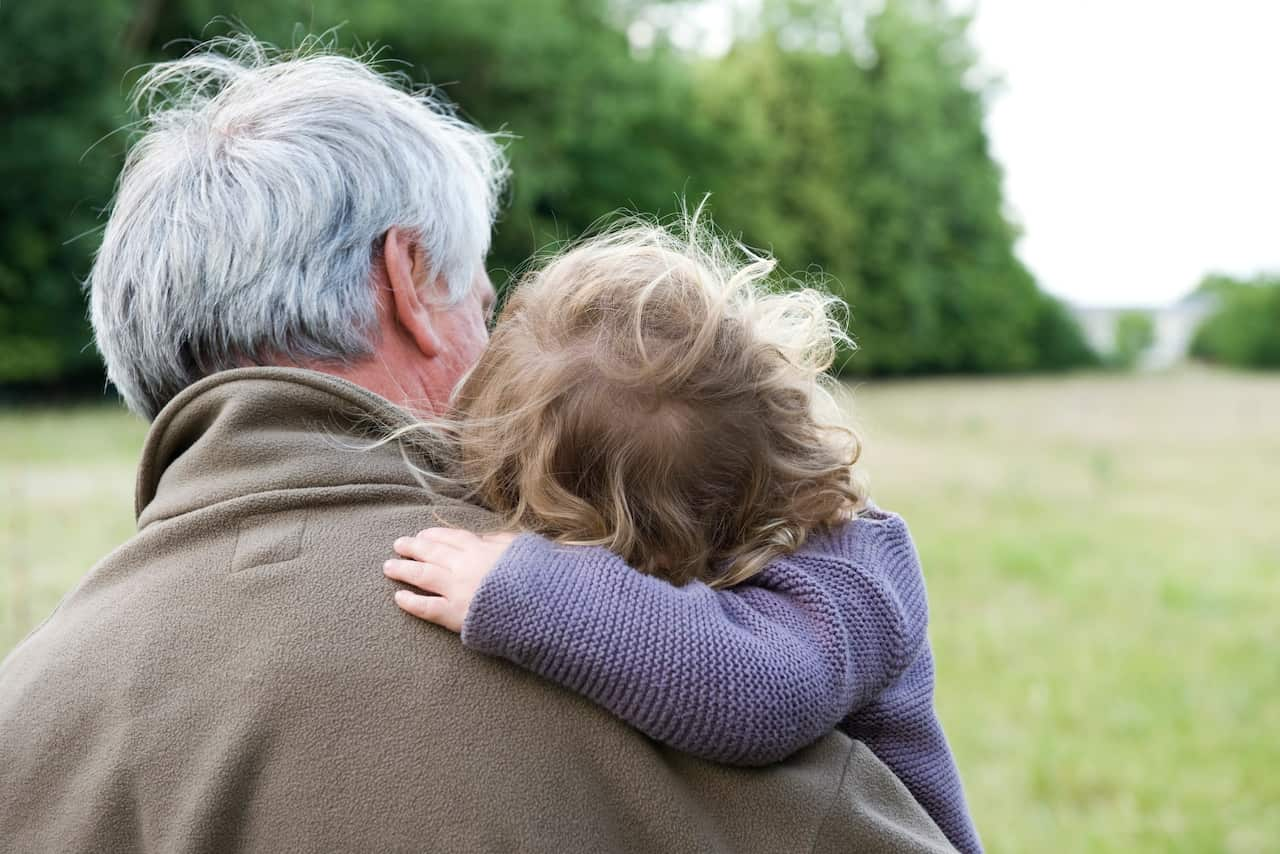 Elderly man holding toddler