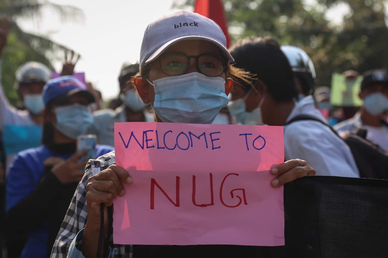 A demonstrator holds a banner that shows support for the National Unity Government (NUG), formed by leaders of the anti-coup protest and ethnic minority leaders