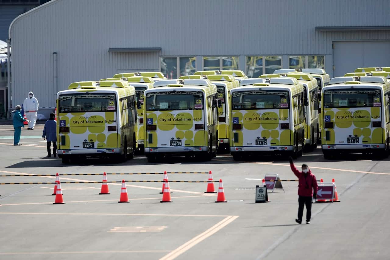Buses wait for the passengers disembarking from the quarantined Diamond Princess cruise ship