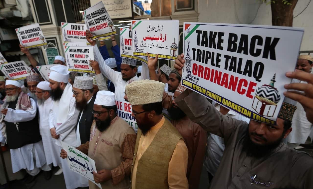 Indian Muslim people hold placards and shouts anti-government slogans during a protest against approving an ordinance to ban triple talaq in Mumbai,