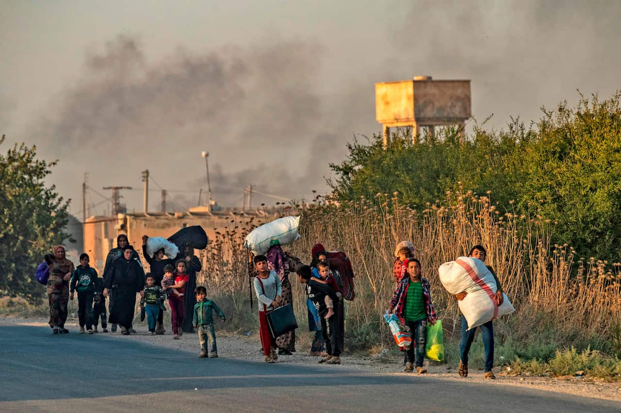 Civilians flee with their belongings amid Turkish bombardment on Syria's northeastern town of Ras al-Ain