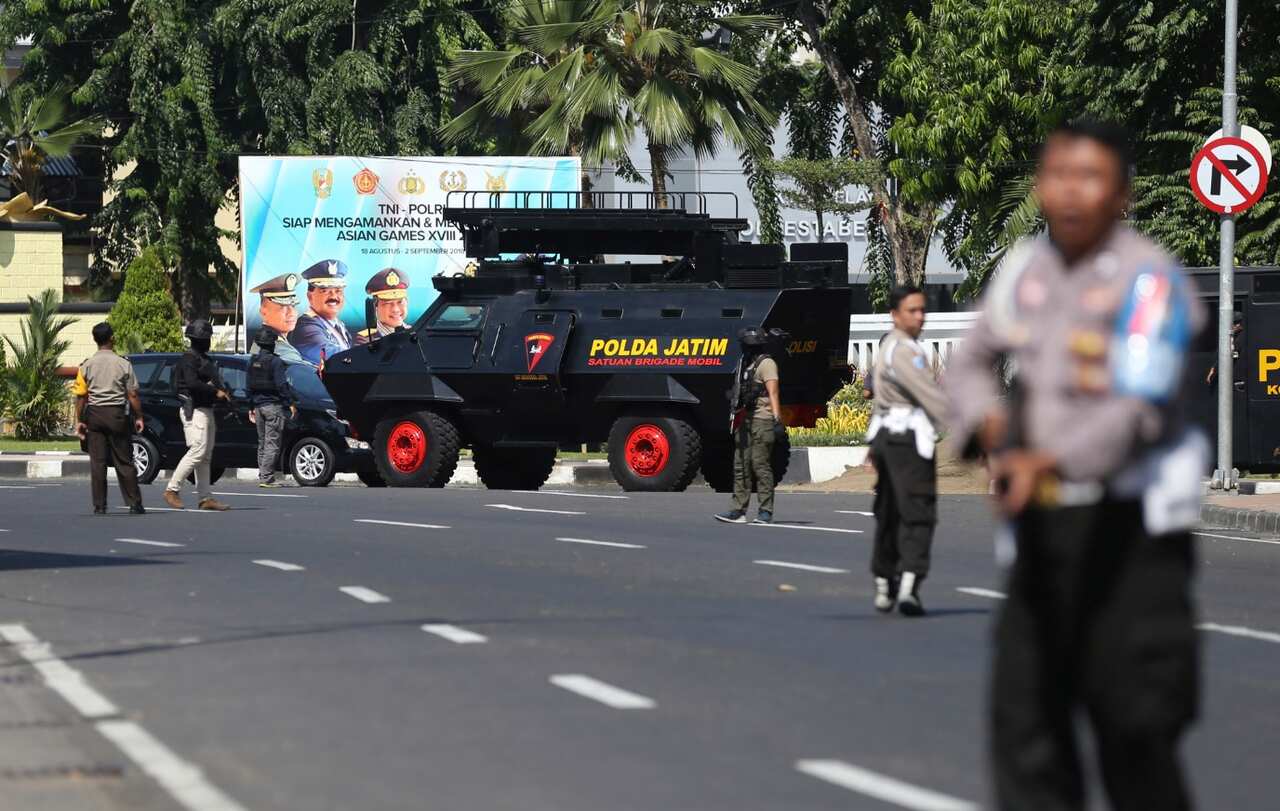 Officers block a road following an attack at the local police headquarters in Surabaya, East Java, Indonesia, Monday, May 14, 2018. 