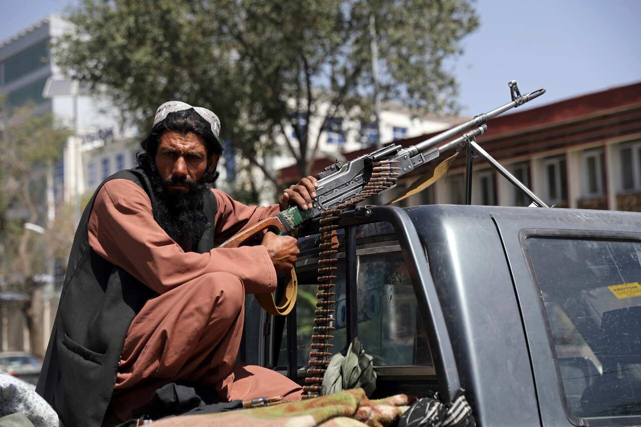 A Taliban fighter in front of main gate leading to the Afghan presidential palace in Kabul.