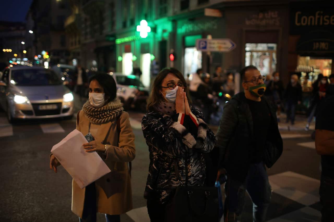 A woman prays in the street near the Notre Dame church in Nice, southern France. 