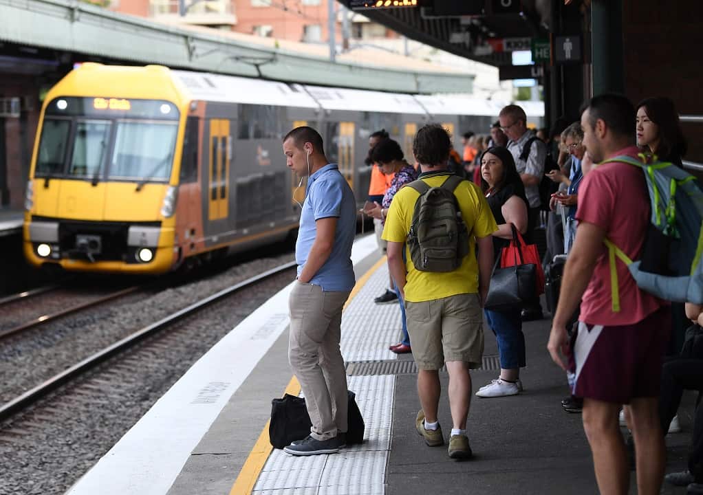 Pictured is a file image of commuters stand on a platform at Strathfield train station in Sydney.
