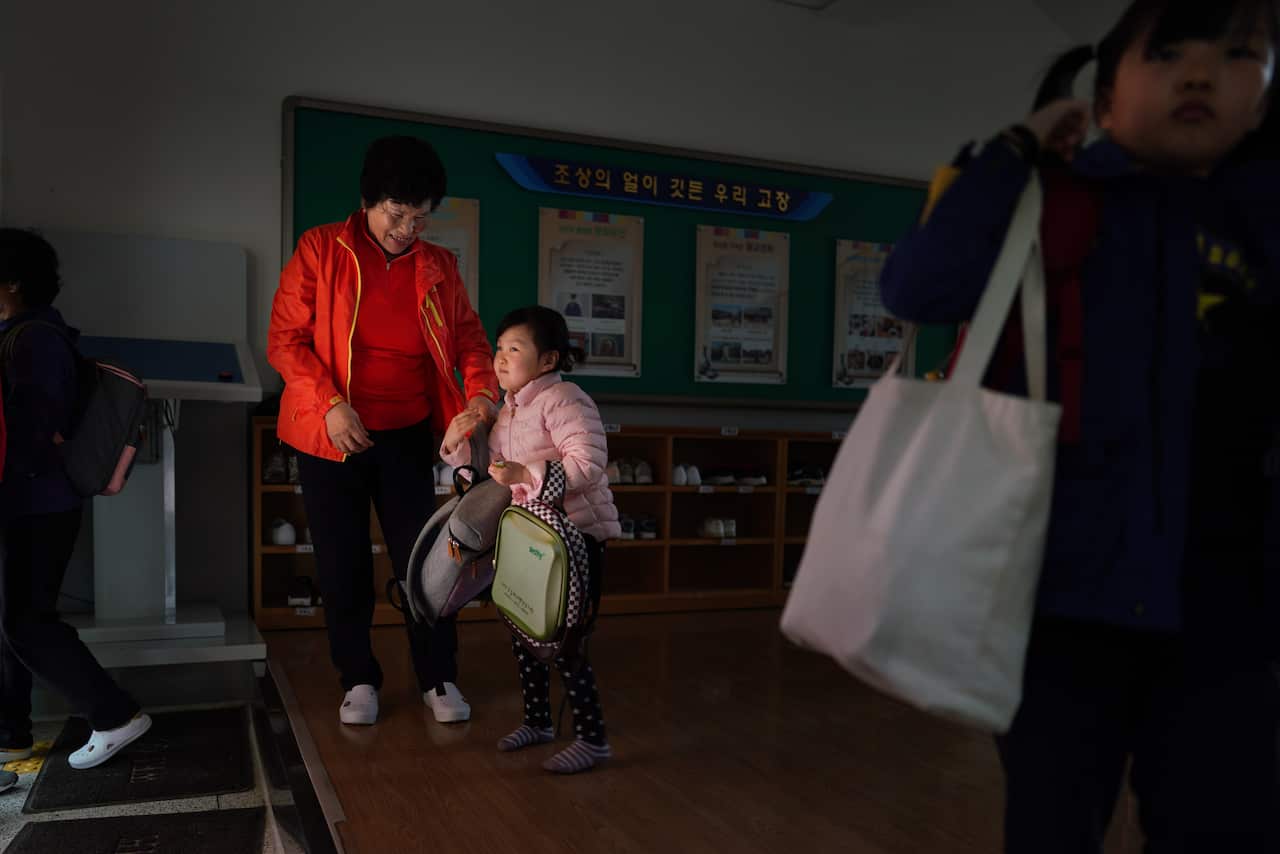 Hwang Wol-geum, 70, and her granddaughter, Soo-hee, arrive for classes  at Daegu Elementary, in Gangjin County, South Korea. 