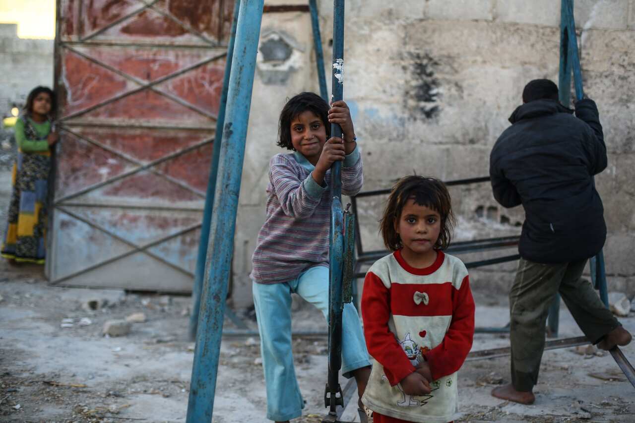Migrant children play on a damaged swing, in Autaya, Eastern al-Ghouta, Syria.