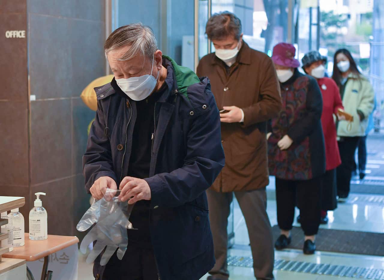 A queue forms at a polling station in Seoul