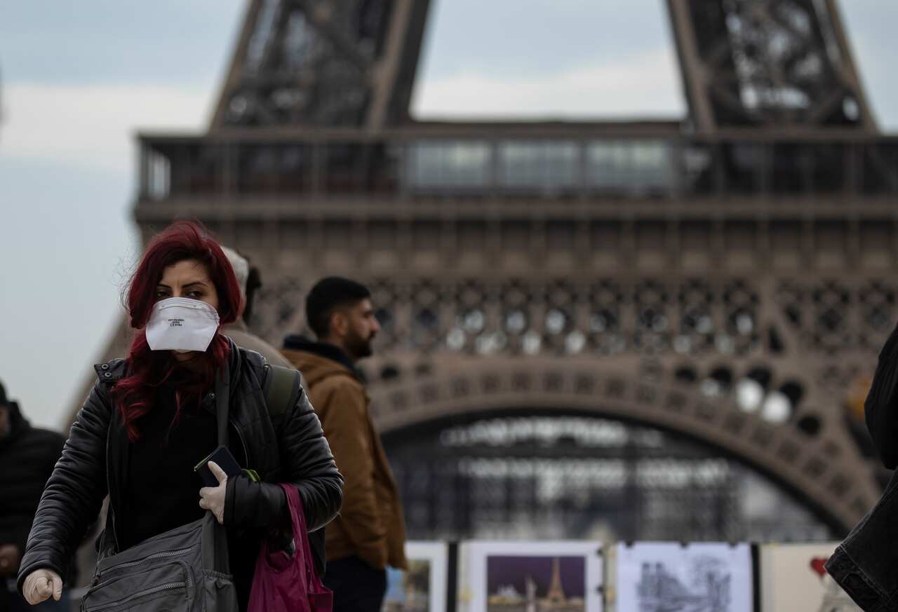 A woman wears a protective face mask near the Eiffel Tower, in Paris, France.