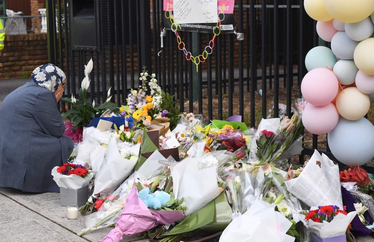 A woman reacts after placing flowers outside Banksia Road Public School in Greenacre, Sydney, Wednesday, November 8, 2017. 
