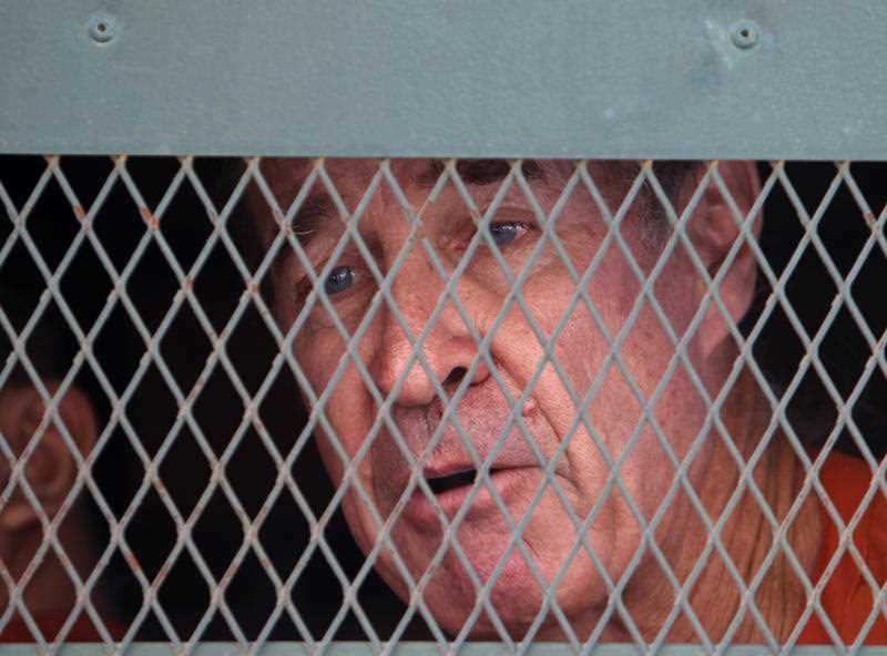 Ricketson talks from inside a prisoner truck upon his arrival at Phnom Penh Municipal Court in Phnom Penh, Cambodia.