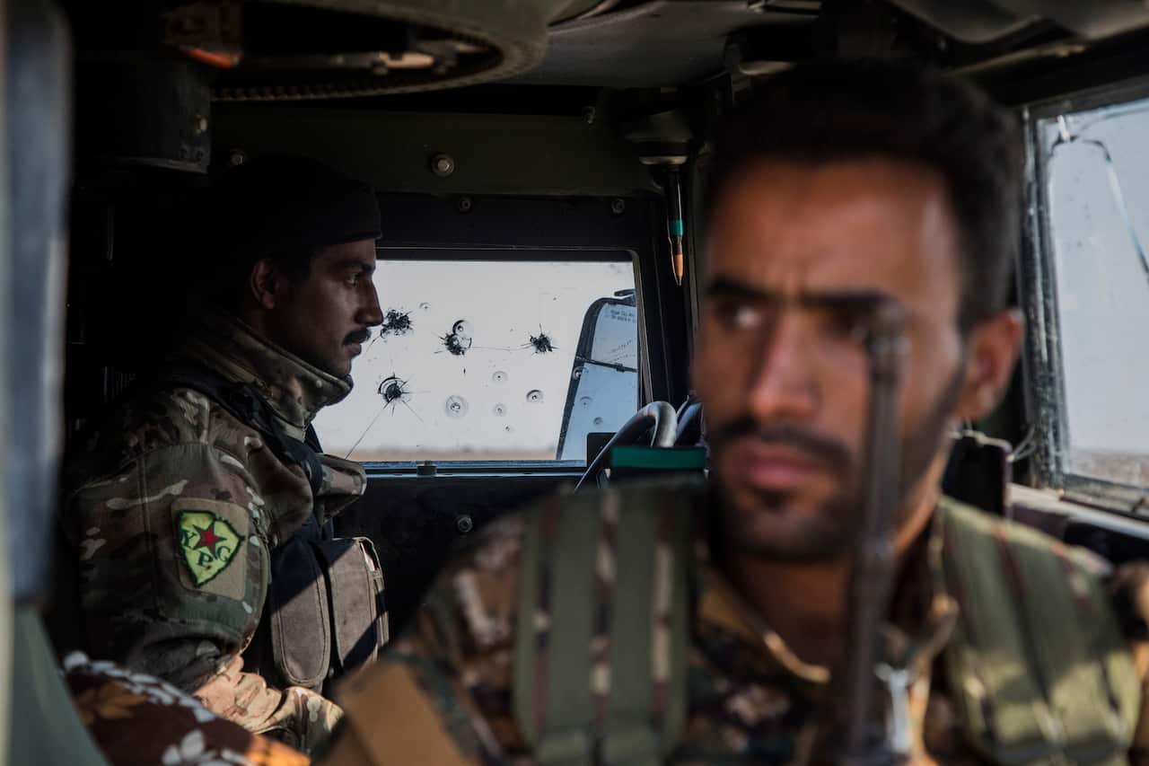 Kurdish forces withdraw from an area near the Turkish border with Syria, overseen by the Russian forces.