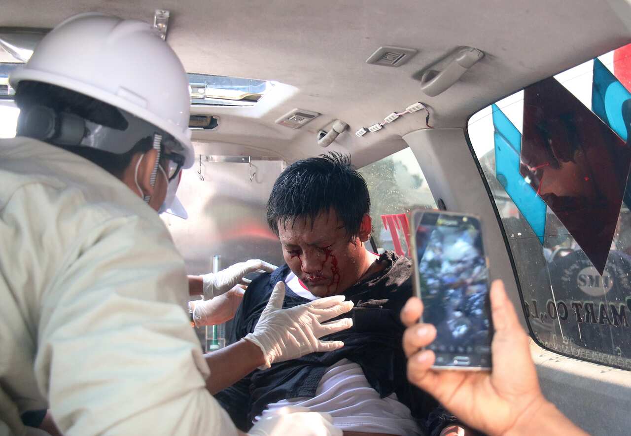 A demonstrator is tended by medics in an ambulance after police fired water cannon on demonstrators during a protest against the military coup, in Naypyitaw.