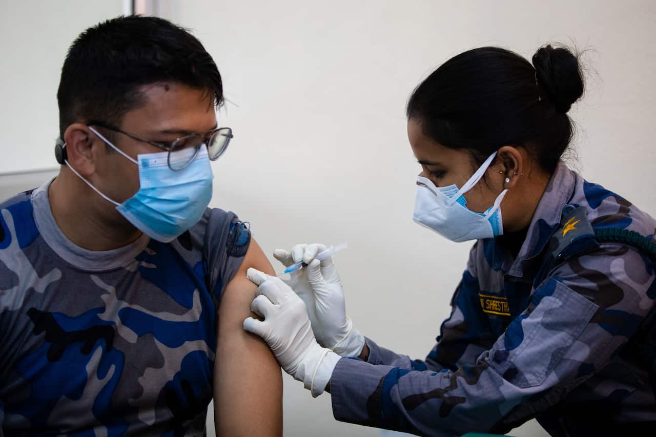 A Nepal's Armed Police Force doctor wearing a mask receives an Oxford-AstraZeneca vaccine dose against the Coronavirus (COVID-19) at the Armed Police Force Hospital.