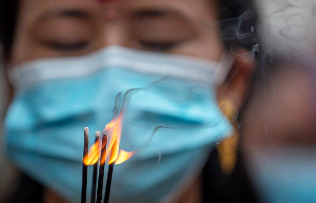  A woman wears a face mask as she worships Lord Shiva (Hindu god of creation and destruction) to mark the Teej festival amid the coronavirus pandemic fear in Kathmandu, Nepal, 09 September 2021.