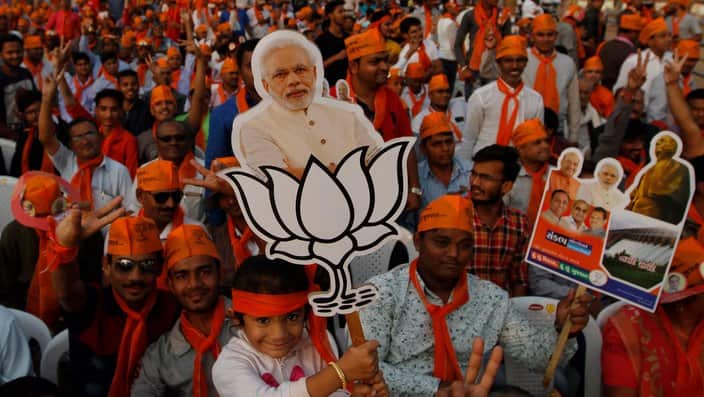 A girl holds cut out of Indian Prime Minister Narendra Modi during an election campaign rally in Ahmadabad, India, Friday, Dec. 8, 2017. 