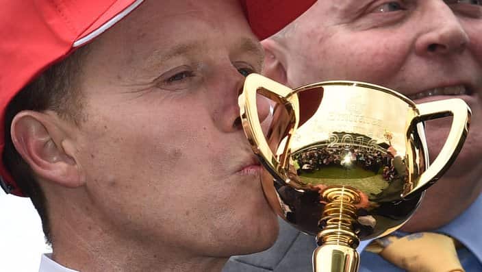 Kerrin McEvoy kisses the Melbourne Cup after Almandin won the race at Flemington Racecourse in Melbourne, Tuesday. Nov. 1, 2016. (AAP Image/Julian Smith) NO ARCHIVING, EDITORIAL USE ONLY