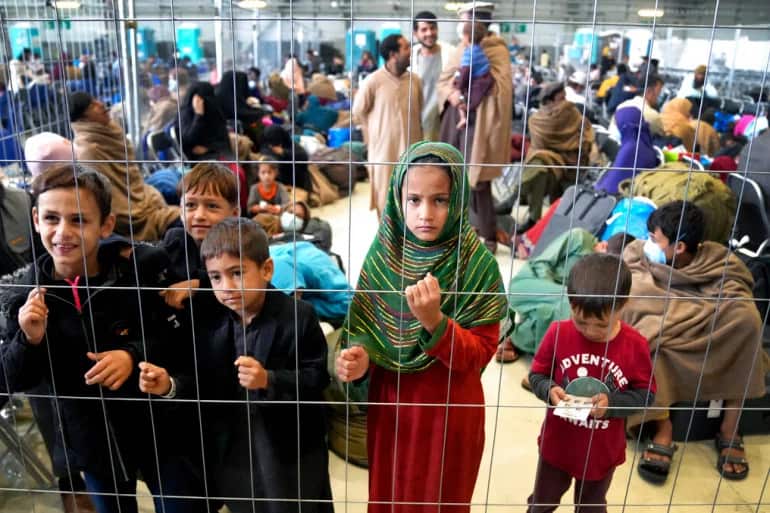 Afghan children stand in a hangar as they wait for their departure at the US air base, Ramstein, in Germany.