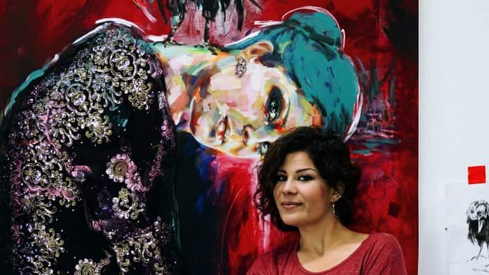 Arya Atti standing in front of her painting