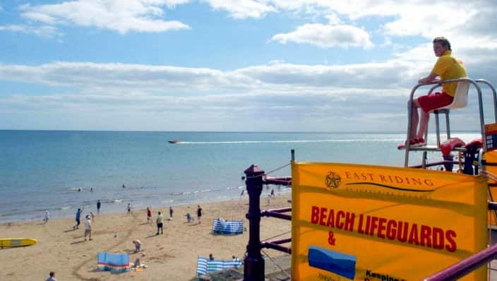 A lifeguard watches over holidaymakers on the beach in Bridlington, East Yorkshire.