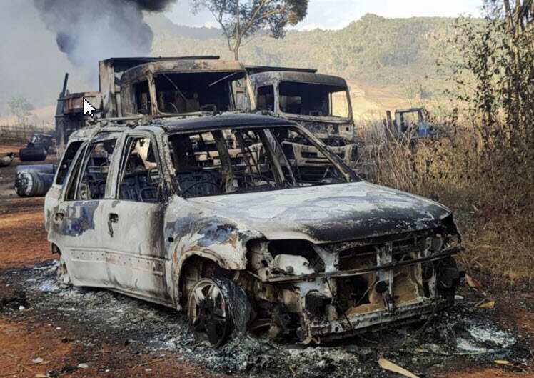 In this photo provided by the Karenni Nationalities Defense Force (KNDF), vehicles smolder in Hpruso township, Kayah state, Myanmar, 24 December, 2021.
