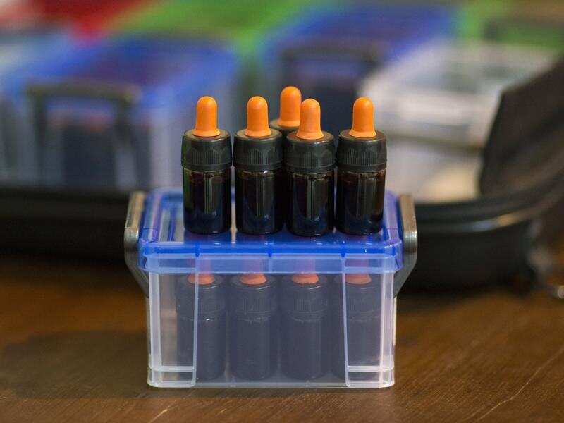 Small bottles of cannabis oil in a container atop a table in Thailand.