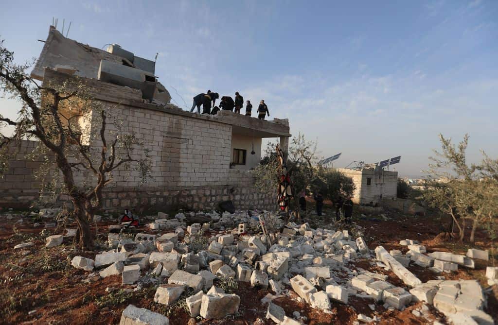 Syrians gather on 3 February, 2022 at the scene following an overnight raid by US special operations forces in Syria's northwestern province of Idlib.