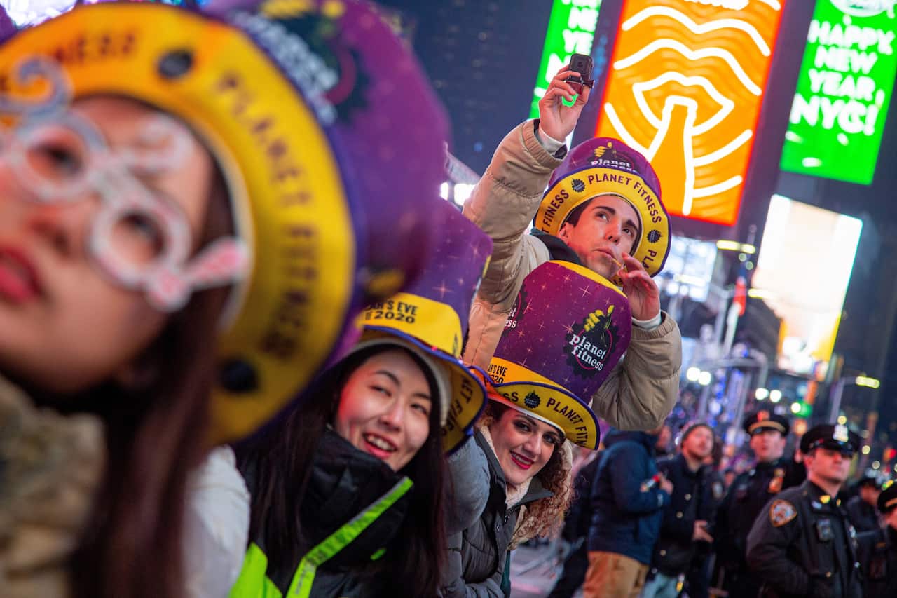 epa08097039 People watch fireworks during New Year's Eve celebrations at Time Square, New York, USA, 31 December 2019. EPA/ANGEL COLMENARES