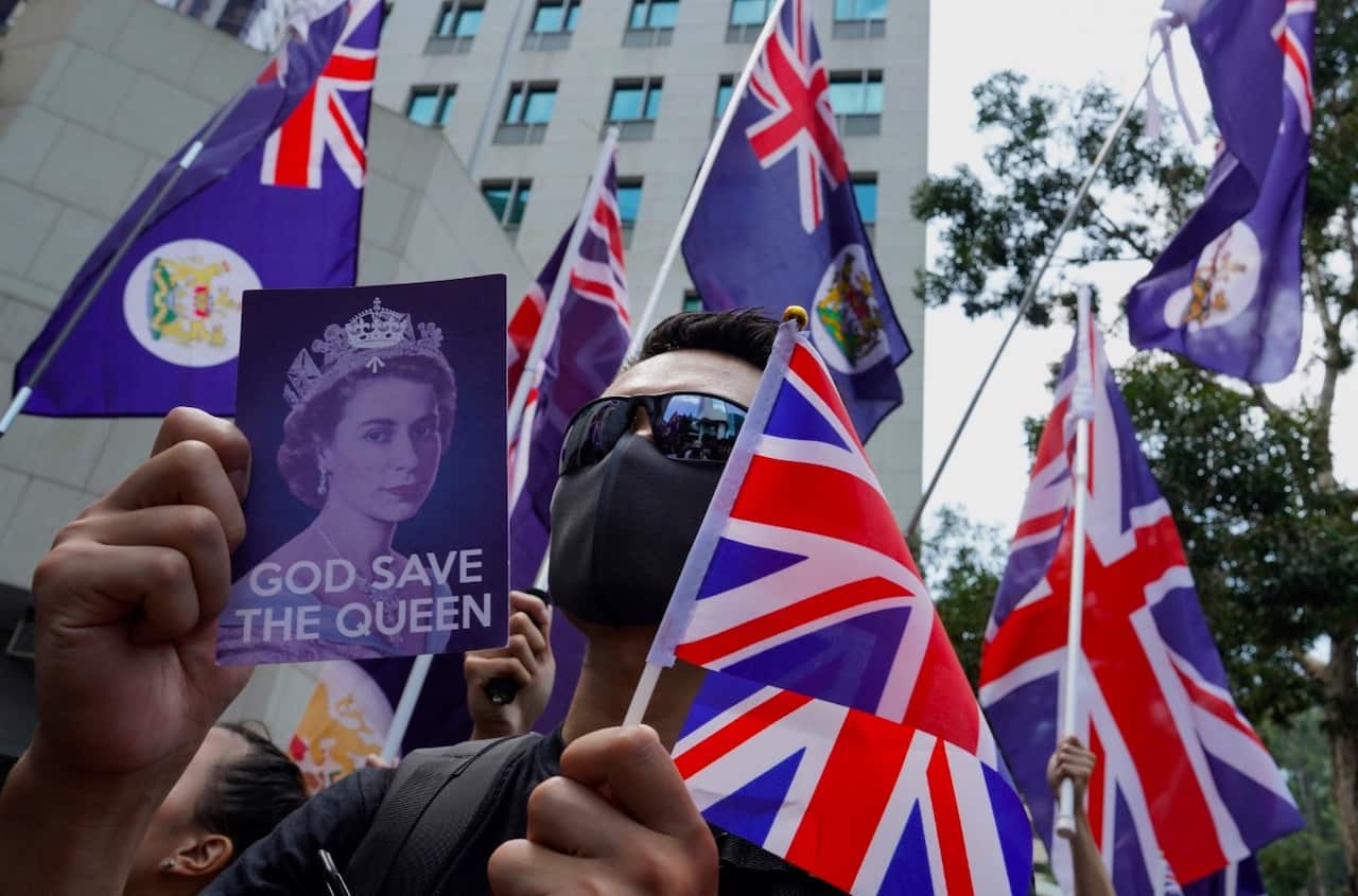 Protesters hold placards and British flags during a peaceful demonstration outside the British Consulate in Hong Kong, Sunday, Sept. 15, 2019.