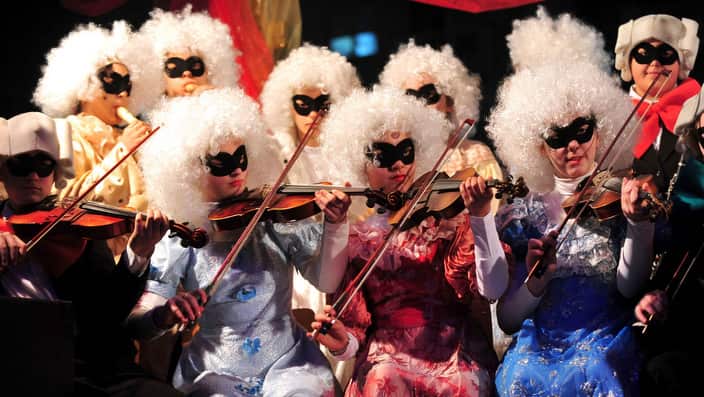 Masked children play violins