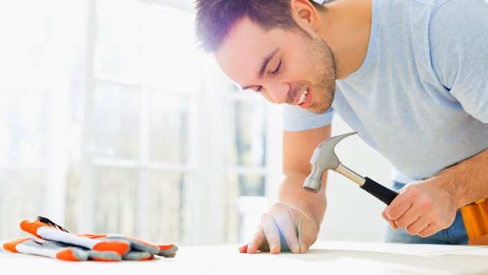 Mid-adult man nailing in table